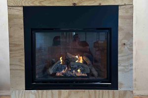 Modern glass fireplace insert with logs and reflection